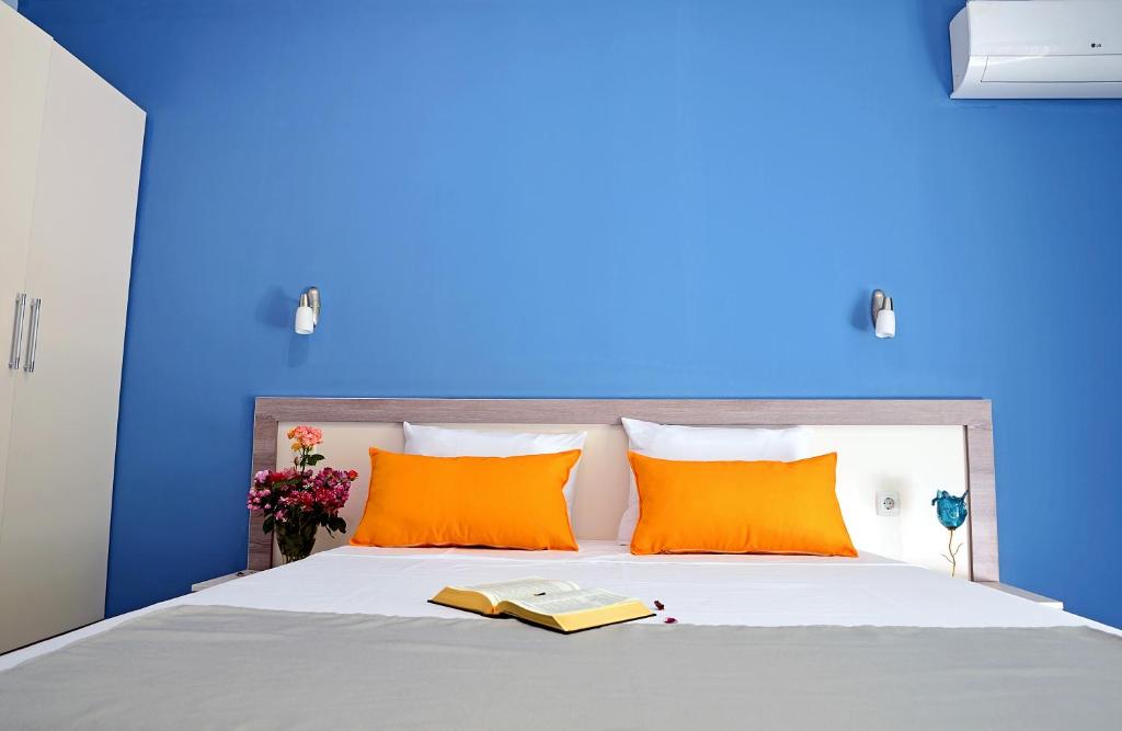 a white bed with a blue comforter on top of it at Visito Aparthouse in Sofia