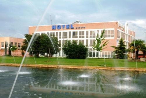 un edificio con una fontana di fronte di Hotel Majadahonda a Majadahonda