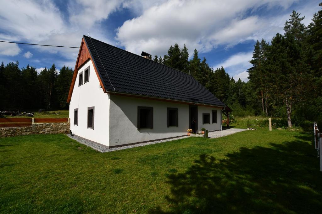 Biały dom z czarnym dachem na dziedzińcu w obiekcie Chalupa Chlum Jiřík w mieście Volary
