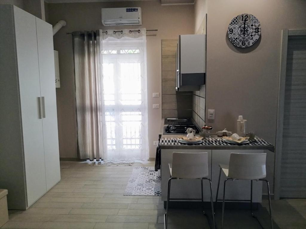 una cucina con tavolo, sedie e finestra di La Maison a Margherita di Savoia