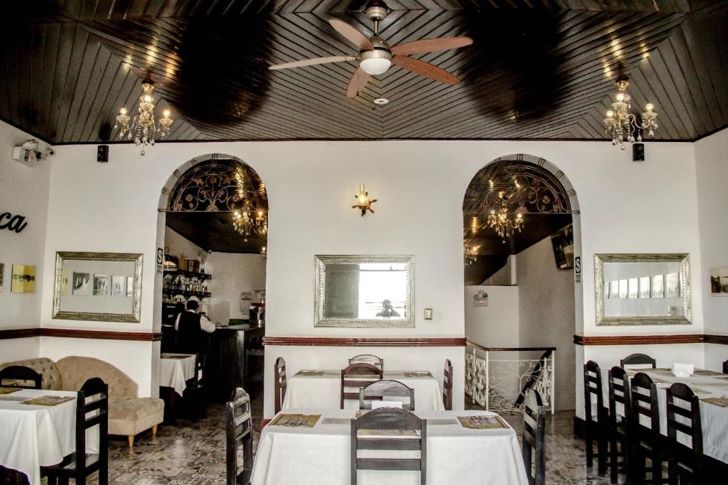 a dining room with two tables and a ceiling fan at Epoca Iquitos in Iquitos