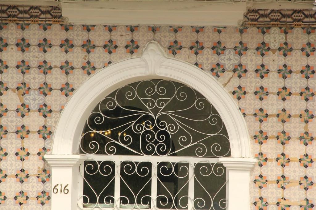 an ornate window in a building with a tile wall at Epoca Iquitos in Iquitos