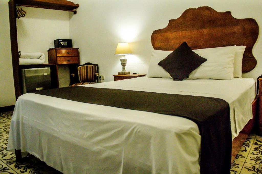 a bedroom with a large bed with a large headboard at Epoca Iquitos in Iquitos