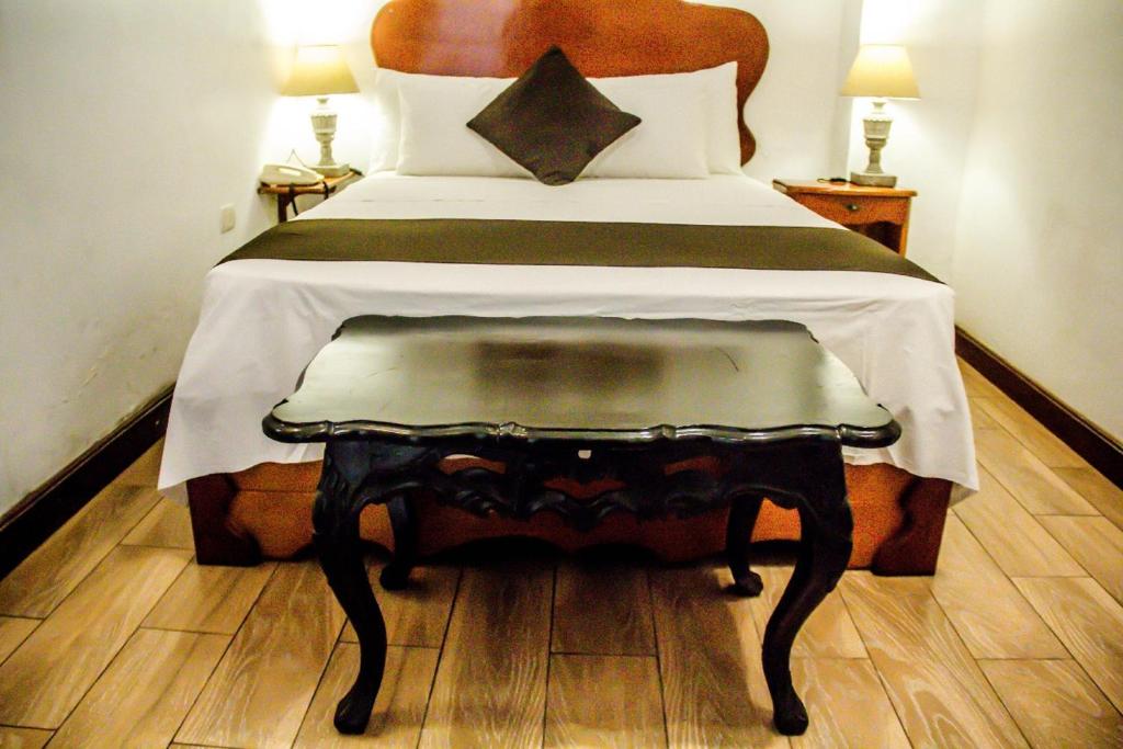 a bedroom with a bed with a table on it at Epoca Iquitos in Iquitos