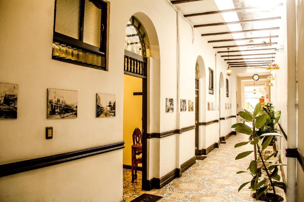 a hallway of a building with pictures on the walls at Epoca Iquitos in Iquitos