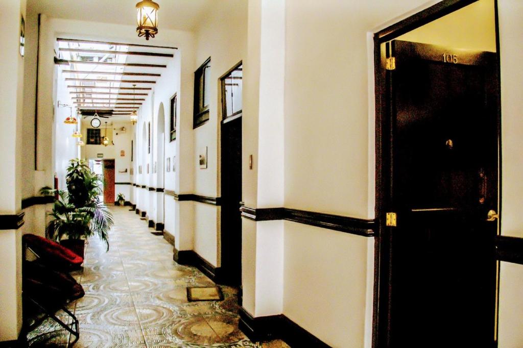 a hallway with white walls and a black door at Epoca Iquitos in Iquitos
