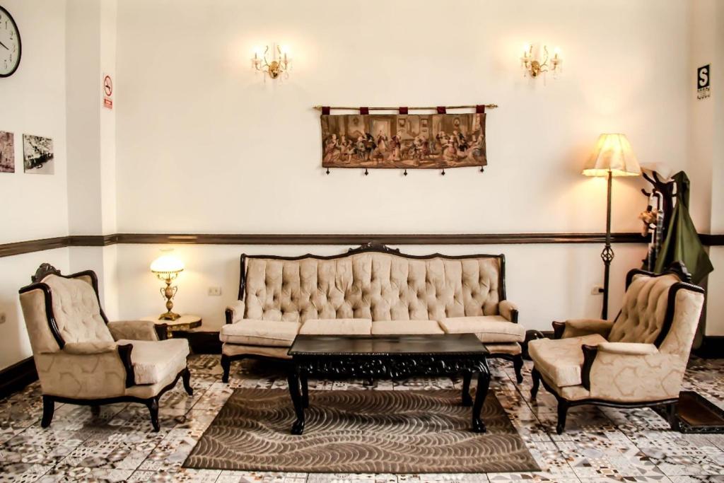a living room with a couch and two chairs at Epoca Iquitos in Iquitos