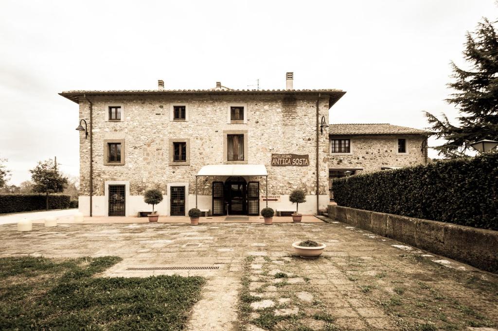 a large stone building with a courtyard in front of it at Agriturismo Antica Sosta in Viterbo