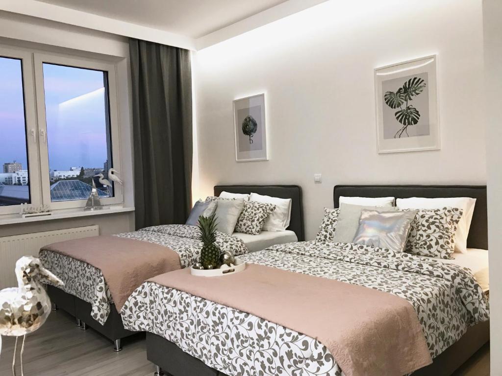 1 dormitorio con 2 camas y ventana en Exclusive Apartments Smolna, en Varsovia