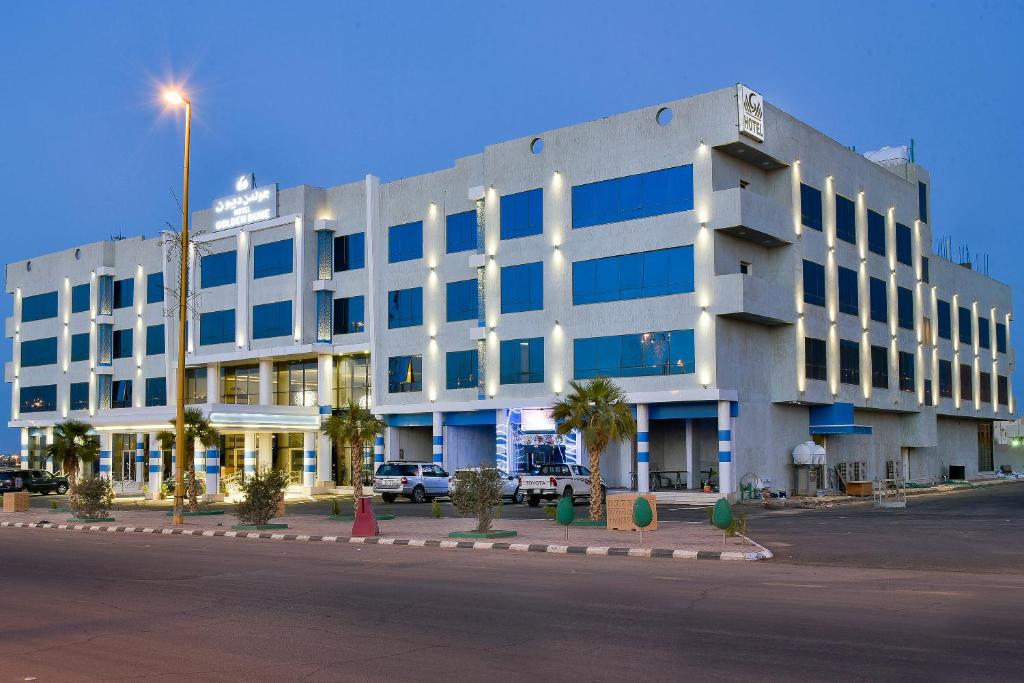 a large white building with a street in front of it at Golden Dune Hotel Turaif in Ţurayf