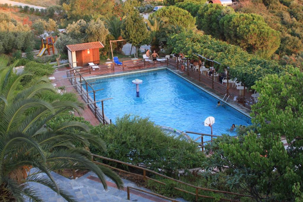 a swimming pool in a resort with people sitting around it at Athorama Hotel in Ouranoupoli