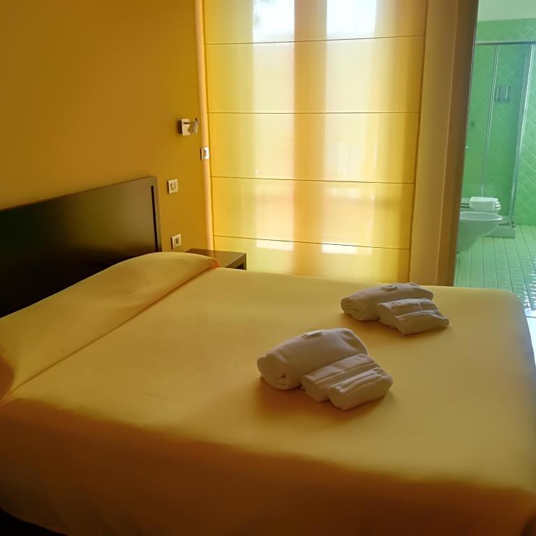 Łóżko lub łóżka w pokoju w obiekcie Hotel I Colori