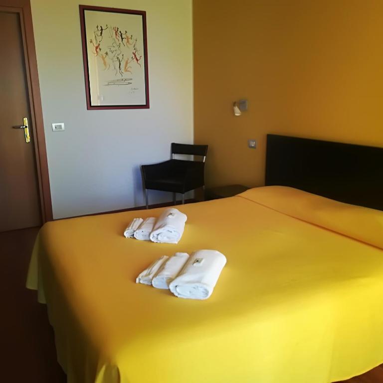 Łóżko lub łóżka w pokoju w obiekcie Hotel I Colori