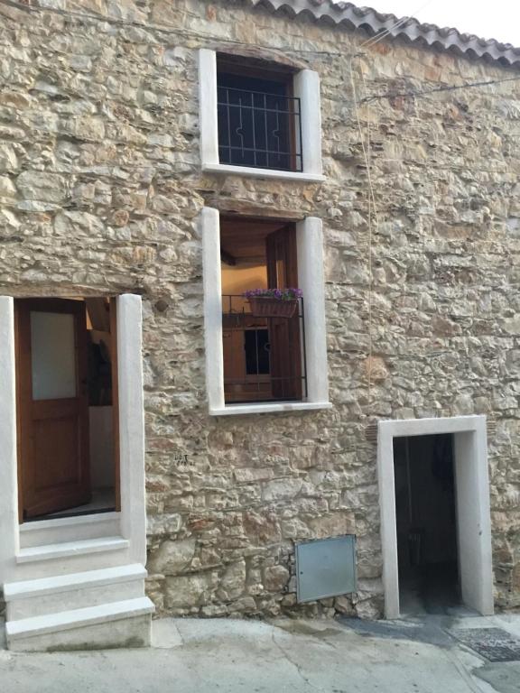 バウネーイにあるDommu sia Luisaの窓と扉が二つある石造りの建物