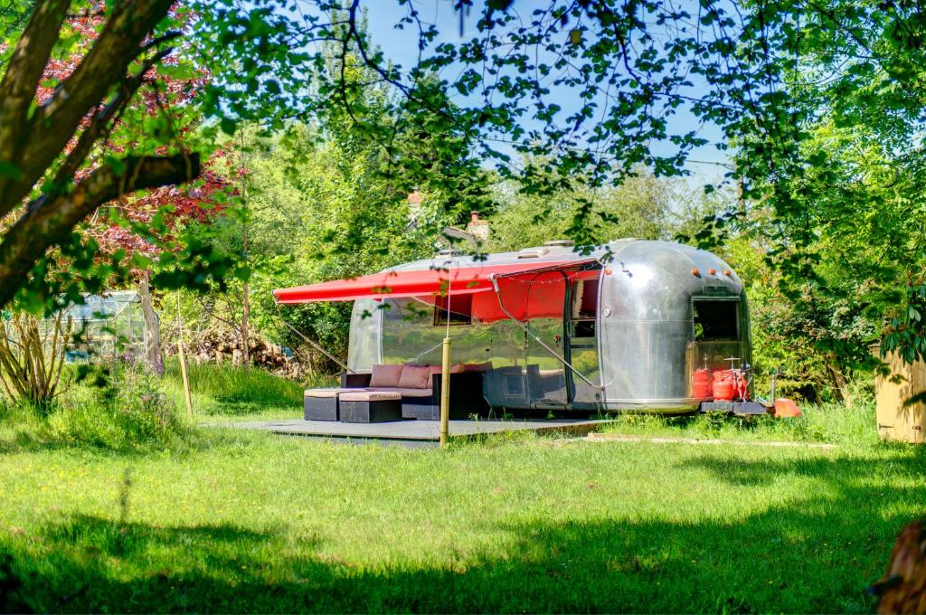 a silver trailer with a red roof in a field at The Airstream in Penryn