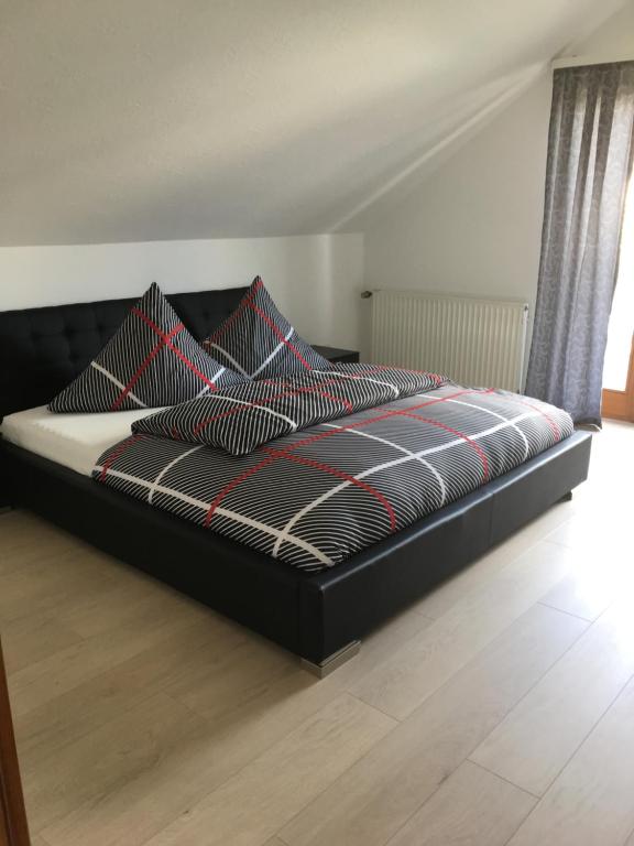 ウールディンゲン・ミュールホーフェンにあるKleine Pauseのベッド(黒と赤のシーツ、枕付)