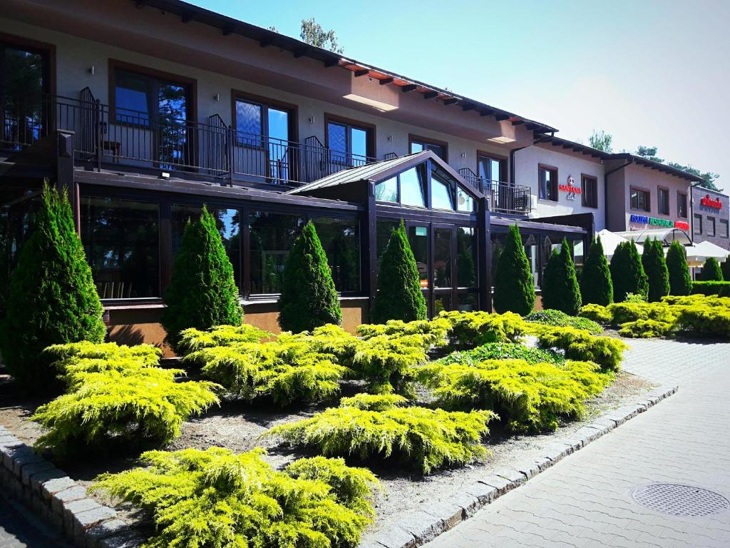 un jardín frente a un edificio con arbustos en Santana Club, en Wielen Zaobrzanski