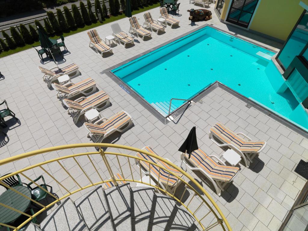 巴德小基希海姆的住宿－高山溫泉公寓酒店，享有带躺椅和滑梯的游泳池的上方景色