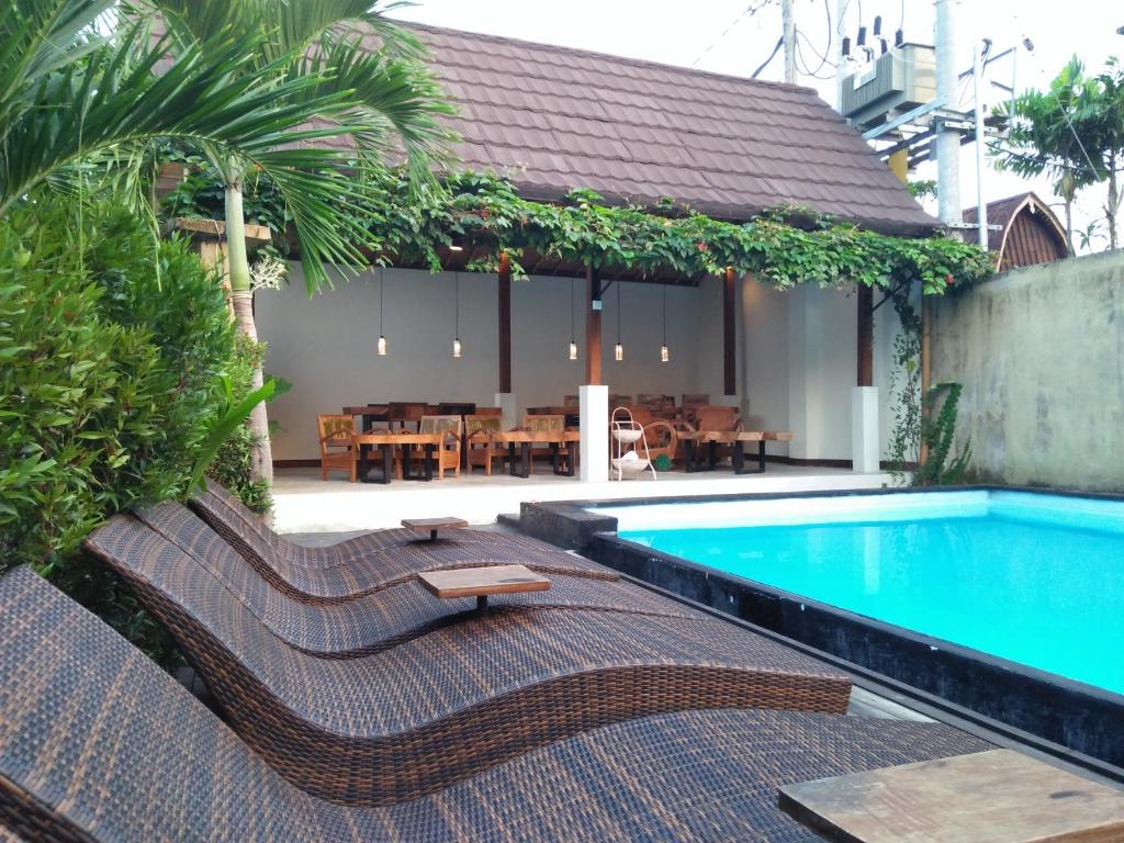 een zwembad met ligstoelen en een restaurant bij De'dalam 2 Bedroom in Ubud