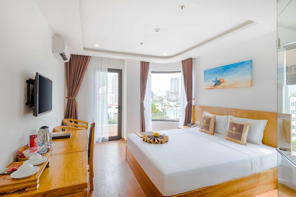 a bedroom with a large white bed and a desk at Rosabella Boutique Hotel in Da Nang