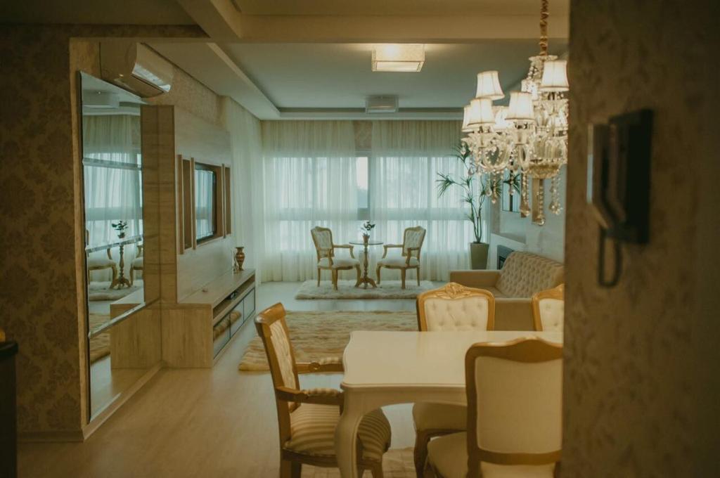 comedor y sala de estar con mesa y sillas en Altos da Bela Vista Gramado centro locação de temporada en Gramado