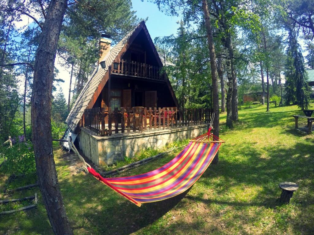 a hammock in front of a log cabin at Ethno Cottage "Biljana" in Zlatibor
