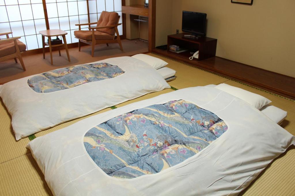 two beds sitting on the floor in a room at Miyajima Seaside Hotel in Miyajima