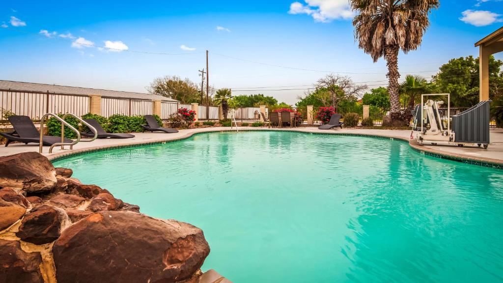 a swimming pool with blue water in a resort at SureStay Hotel by Best Western Floresville in Floresville