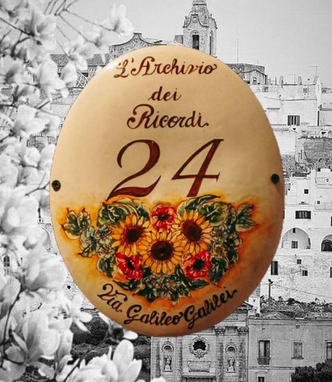a sign with flowers on it in front of a building at Archivio dei Ricordi - Casa con vista a Ostuni in Ostuni