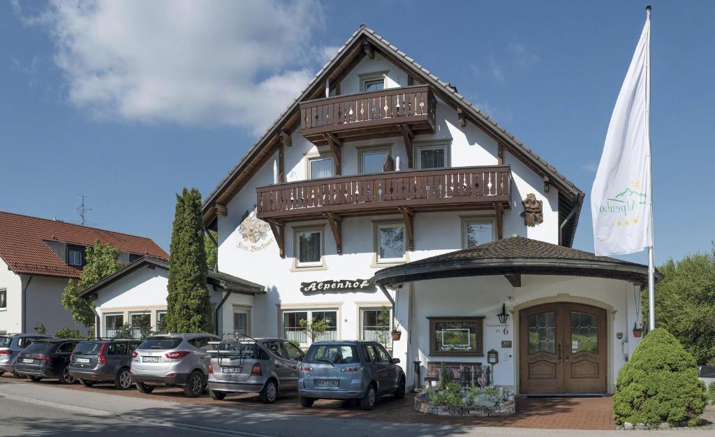 un edificio con coches estacionados frente a él en Hotel Alpenhof, en Bad Wörishofen