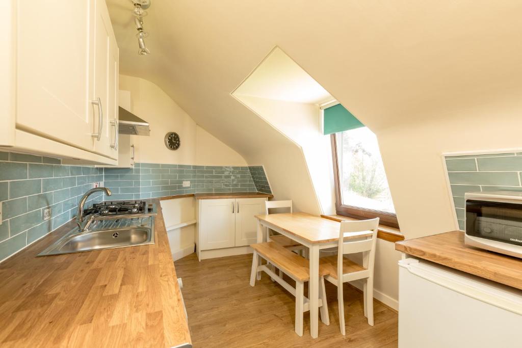 a kitchen with a sink and a table with chairs at The Loft, Inverness in Inverness