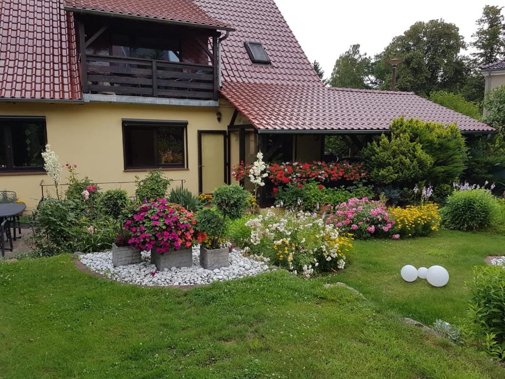a garden in front of a house with flowers at Ferienwohnung Auszeit Bad Belzig Näthe in Bad Belzig