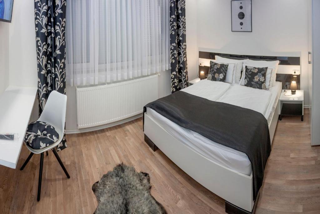 1 dormitorio con cama, silla y escritorio en Villa Onix, en Bihać