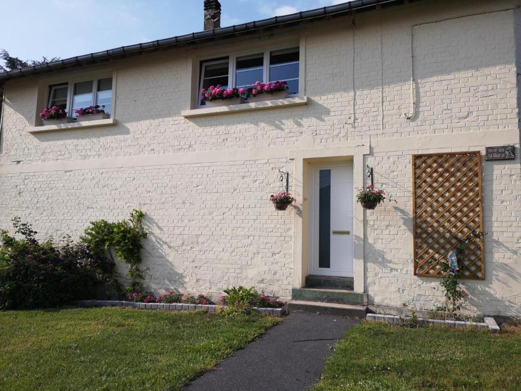 een wit bakstenen huis met twee ramen en bloembakken bij Appartement Liartais - Accueil Chevaux - Horse Friendly in Liart