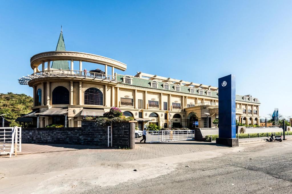 a large building with a tower on top of it at Golden Chariot Vasai Hotel in Vasai