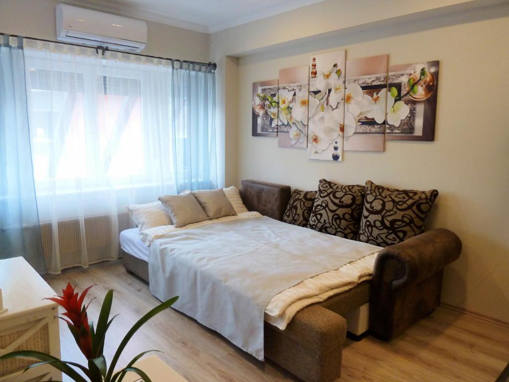 a bedroom with a bed and a couch in it at VárLak Apartman in Debrecen
