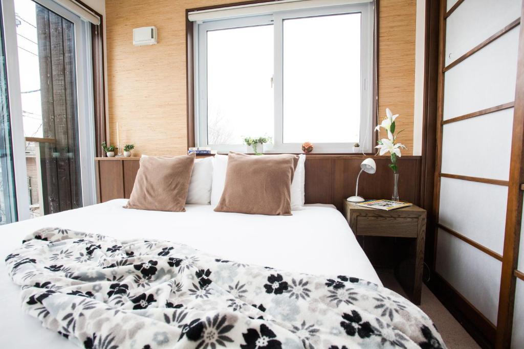 新雪谷的住宿－塔摩度假屋，一间卧室配有一张带黑白毯子的床