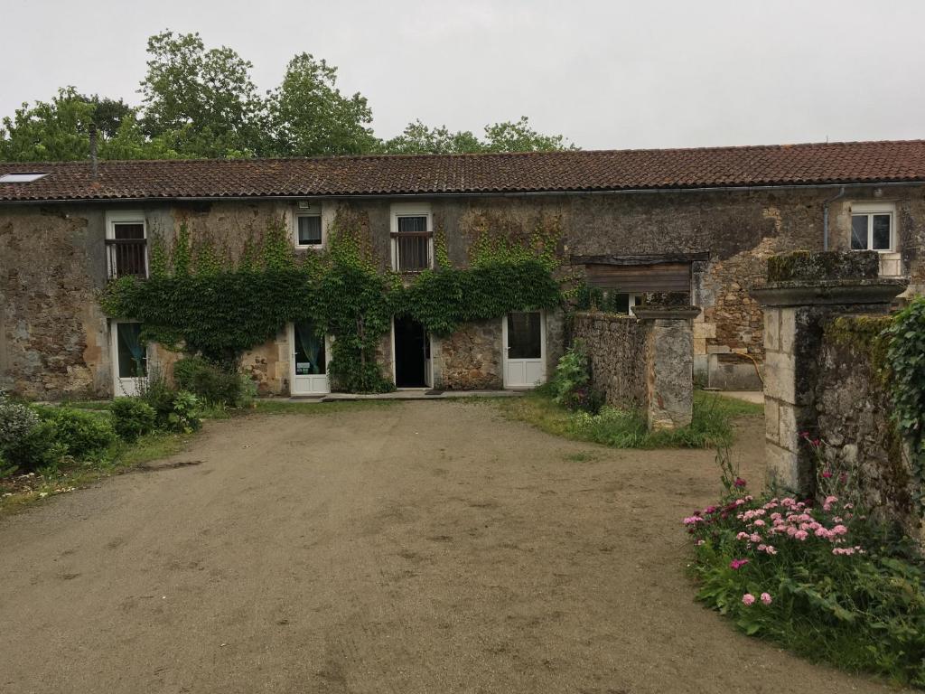 コンフォランにあるFerme Gite Equestre En Charenteの蔦の古い石造りの家