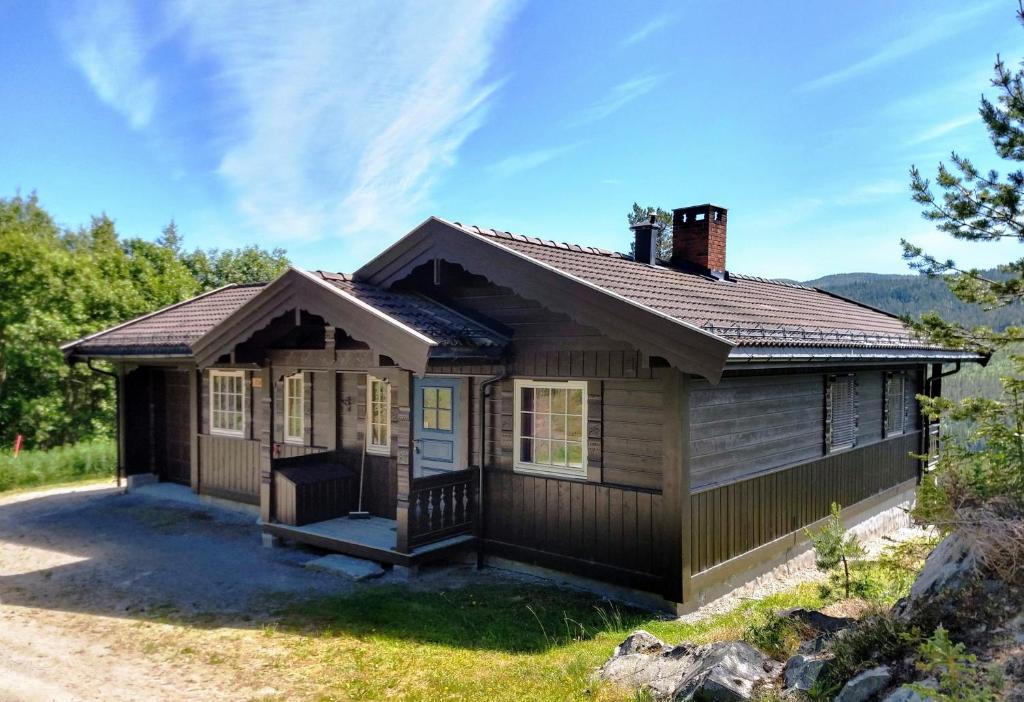 a small house with a brown roof at Hogstul Hytter - Knatten - 3 Bedroom Cottage in Tuddal