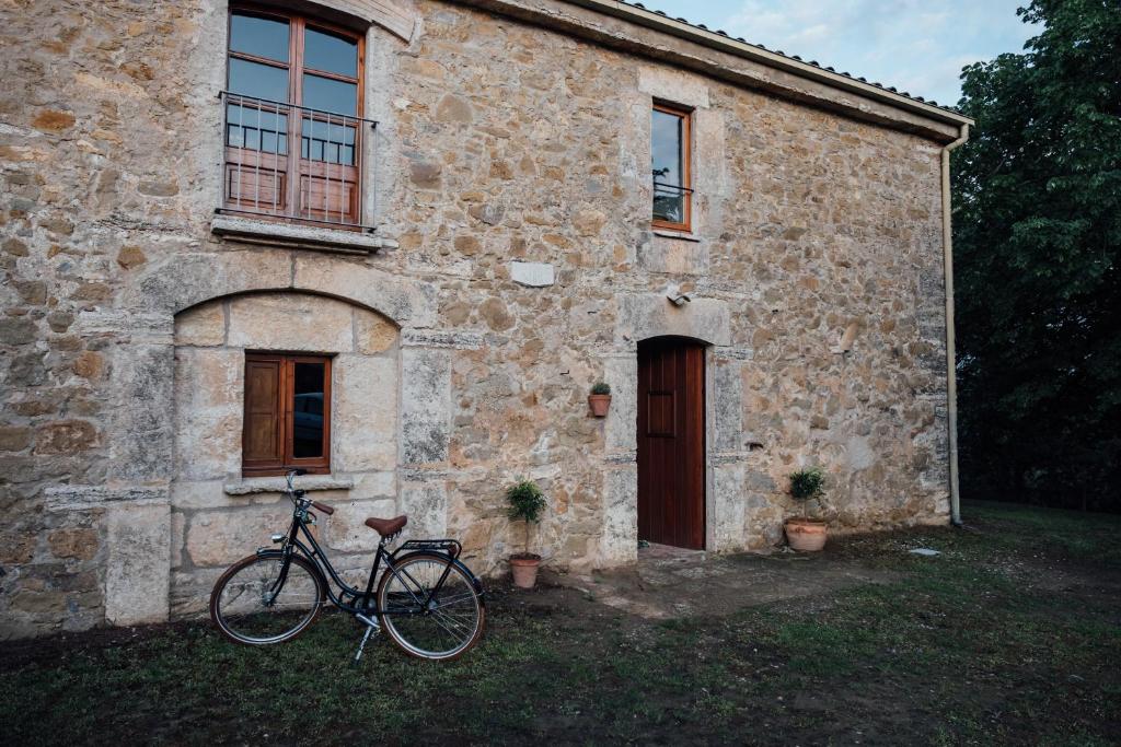 バニョラスにあるVilla Can Benet at Can Campolierの石造りの建物の前に駐車した自転車