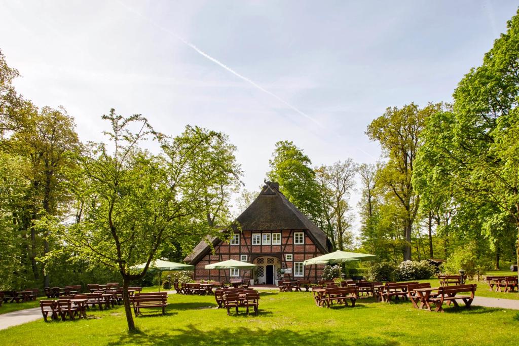 ein Gebäude mit Tischen und Stühlen in einem Park in der Unterkunft Hotel Hof Tütsberg in Behringen