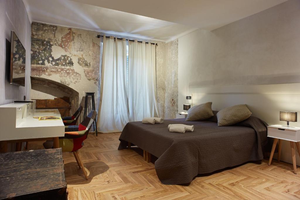 Schlafzimmer mit einem Bett, einem Schreibtisch und einem Fenster in der Unterkunft Casa Spinetta Malaspina - Verona Apartments in Verona