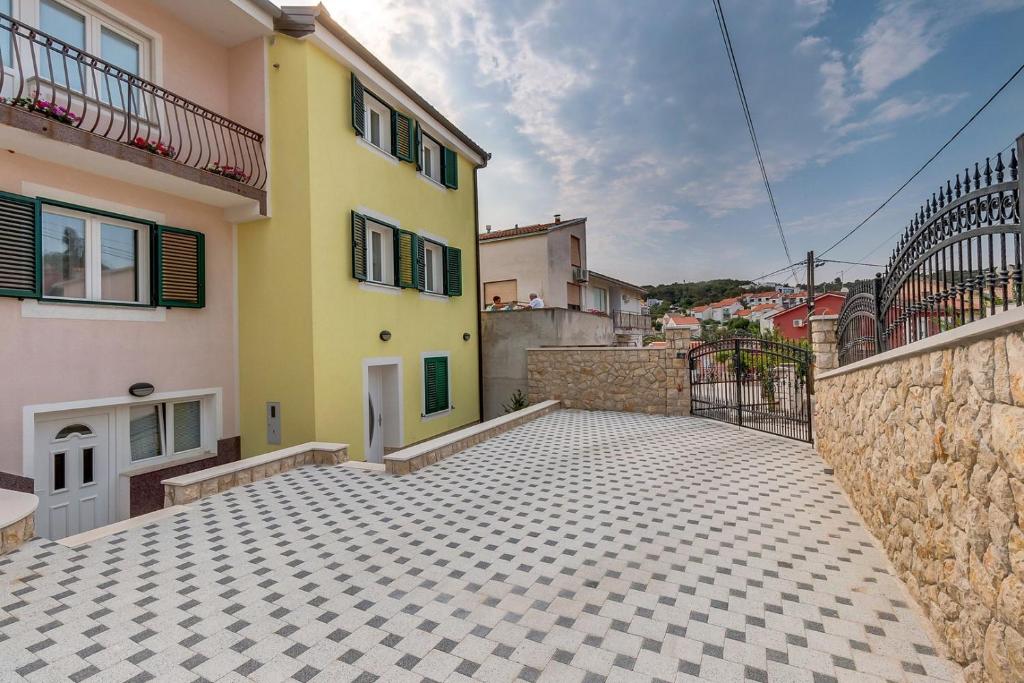 a yellow house with a tile floor and a building at House Baumgarten in Mali Lošinj