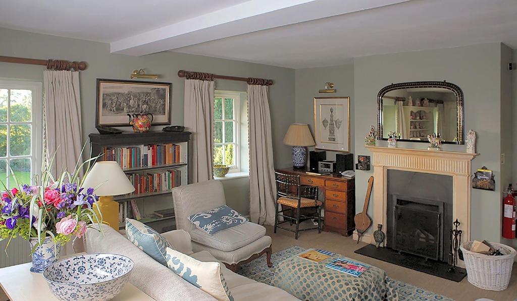 a living room with a couch and a fireplace at Cheltenham Cottage in Bruern