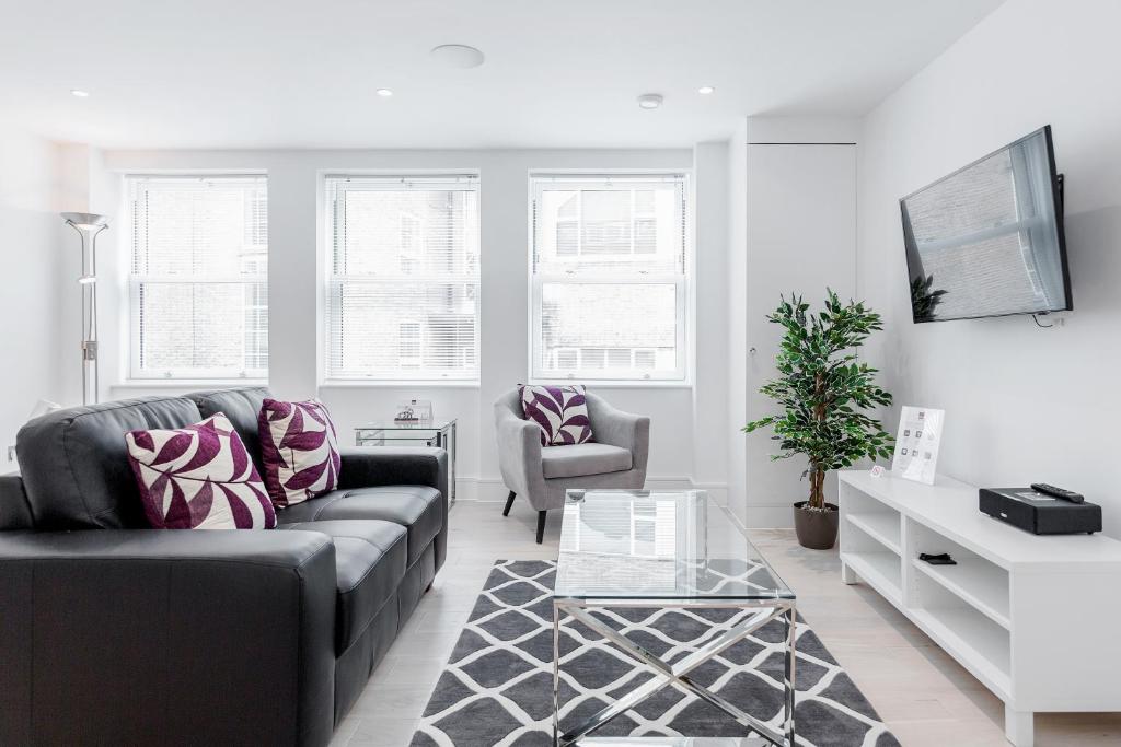 a living room with a couch and two chairs at Roomspace Serviced Apartments- Walpole Court in Ealing