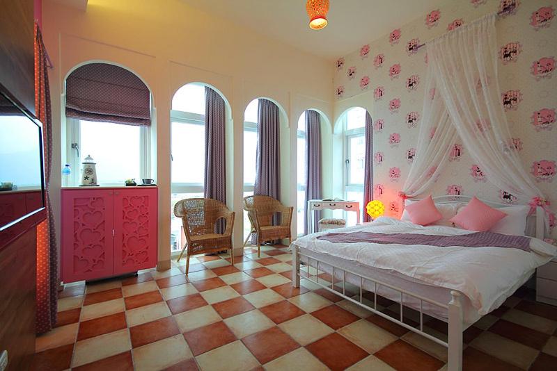 a bedroom with a bed in a room with windows at Lighthouse B&amp;B in Dahan