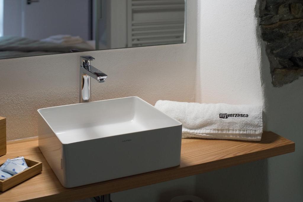 a white bathroom sink sitting on a wooden counter at MyVerzasca Resort Ai piee in Brione