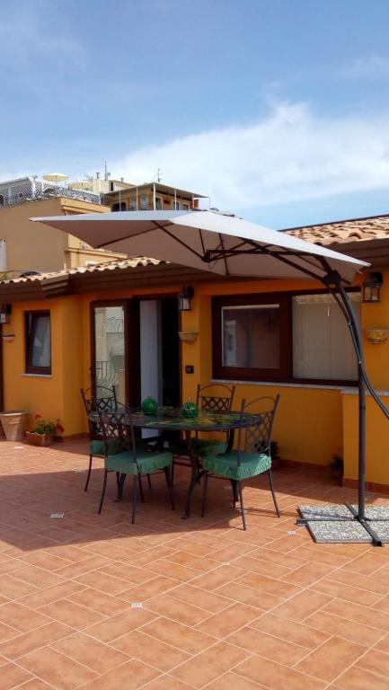 a patio with a table and chairs and an umbrella at Attico Sole Luna in Taormina