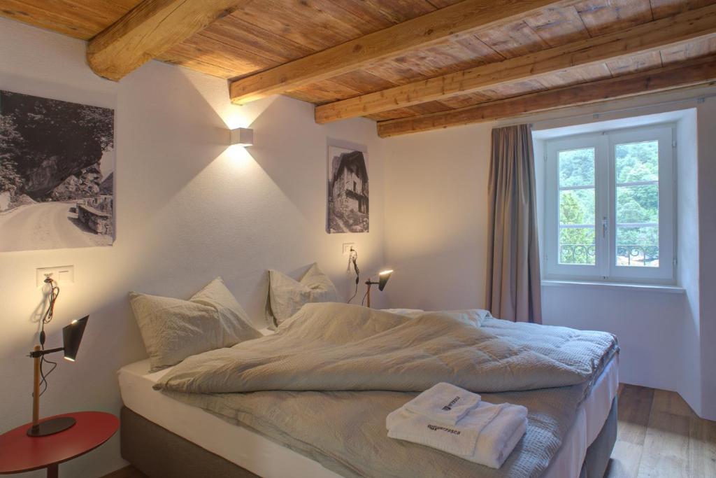a bedroom with a large bed with a window at MyVerzasca Resort Ai piee in Brione