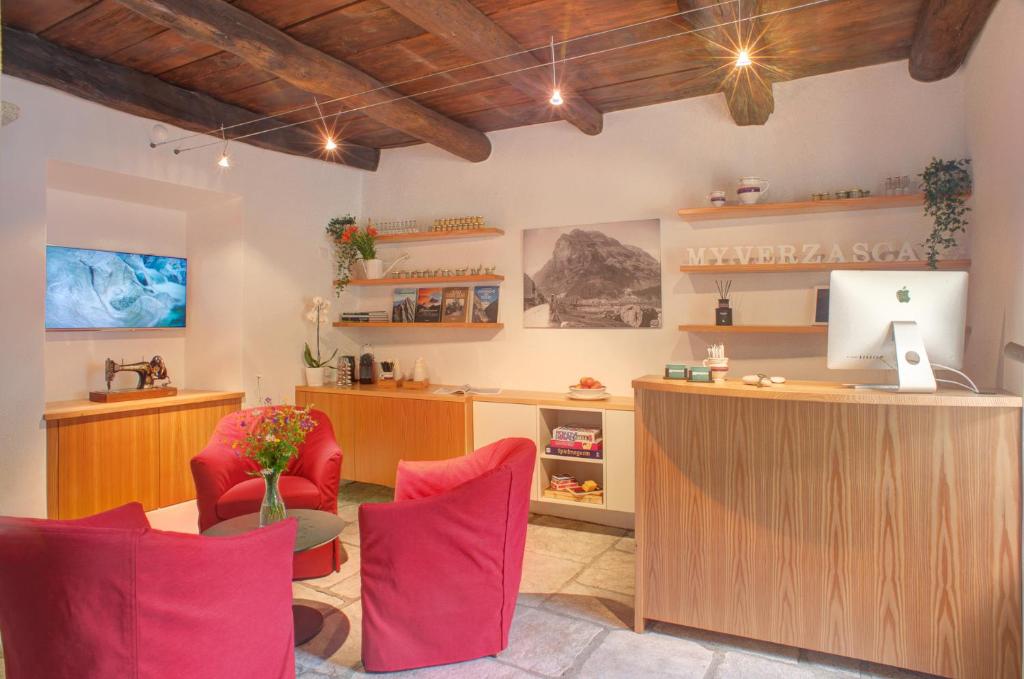 an office with red chairs and a desk with a computer at MyVerzasca Resort Ai piee in Brione